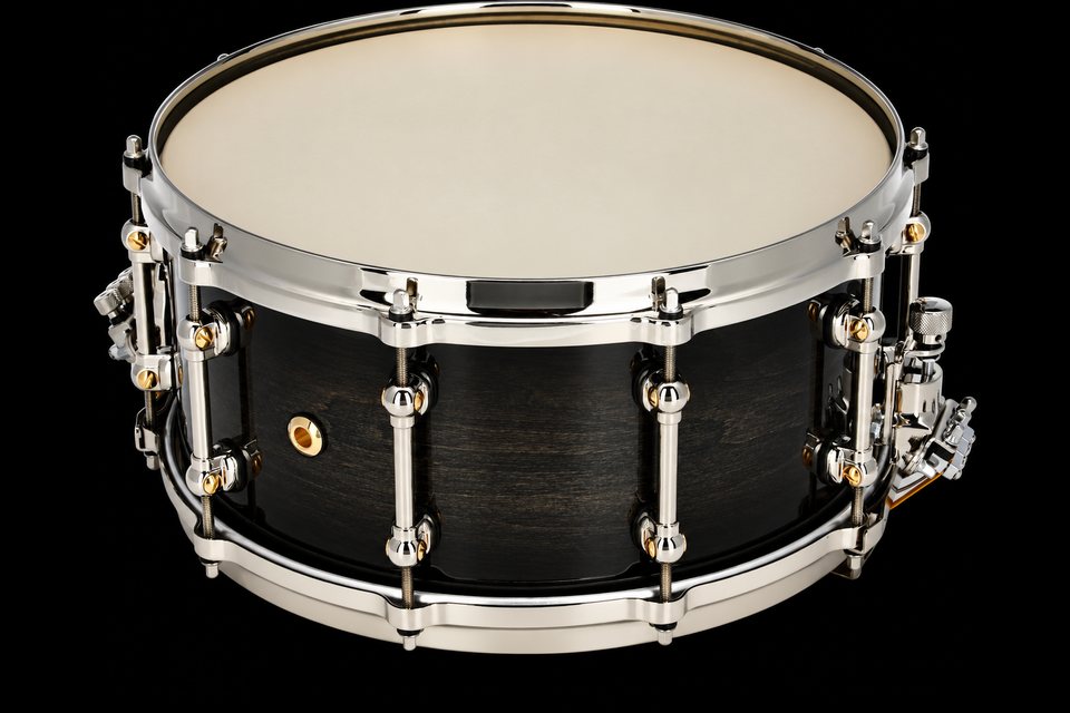 A black wood concert snare drum with chrome hoops and a calfskin-style head